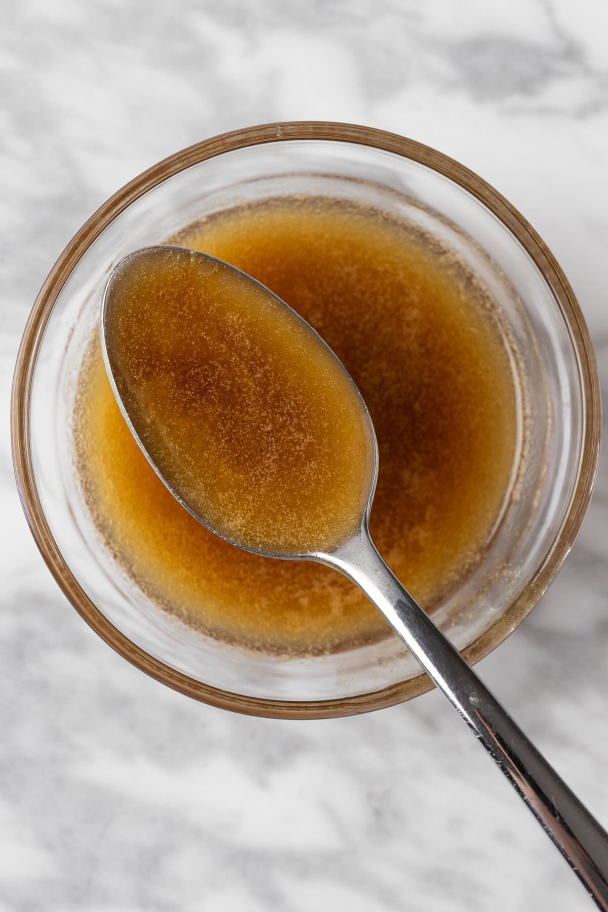 A spoonful of Citrus Balsamic Vinaigrette salad dressing in a small glass bowl.