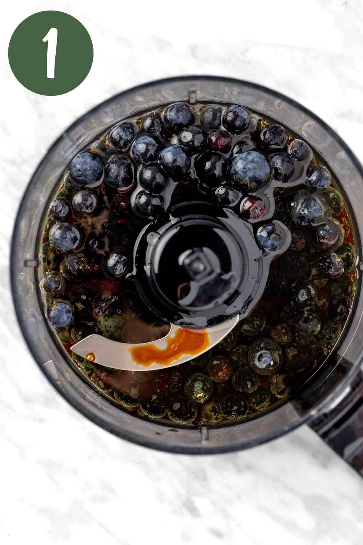 The ingredients to make the blueberry vinaigrette in a food processor.