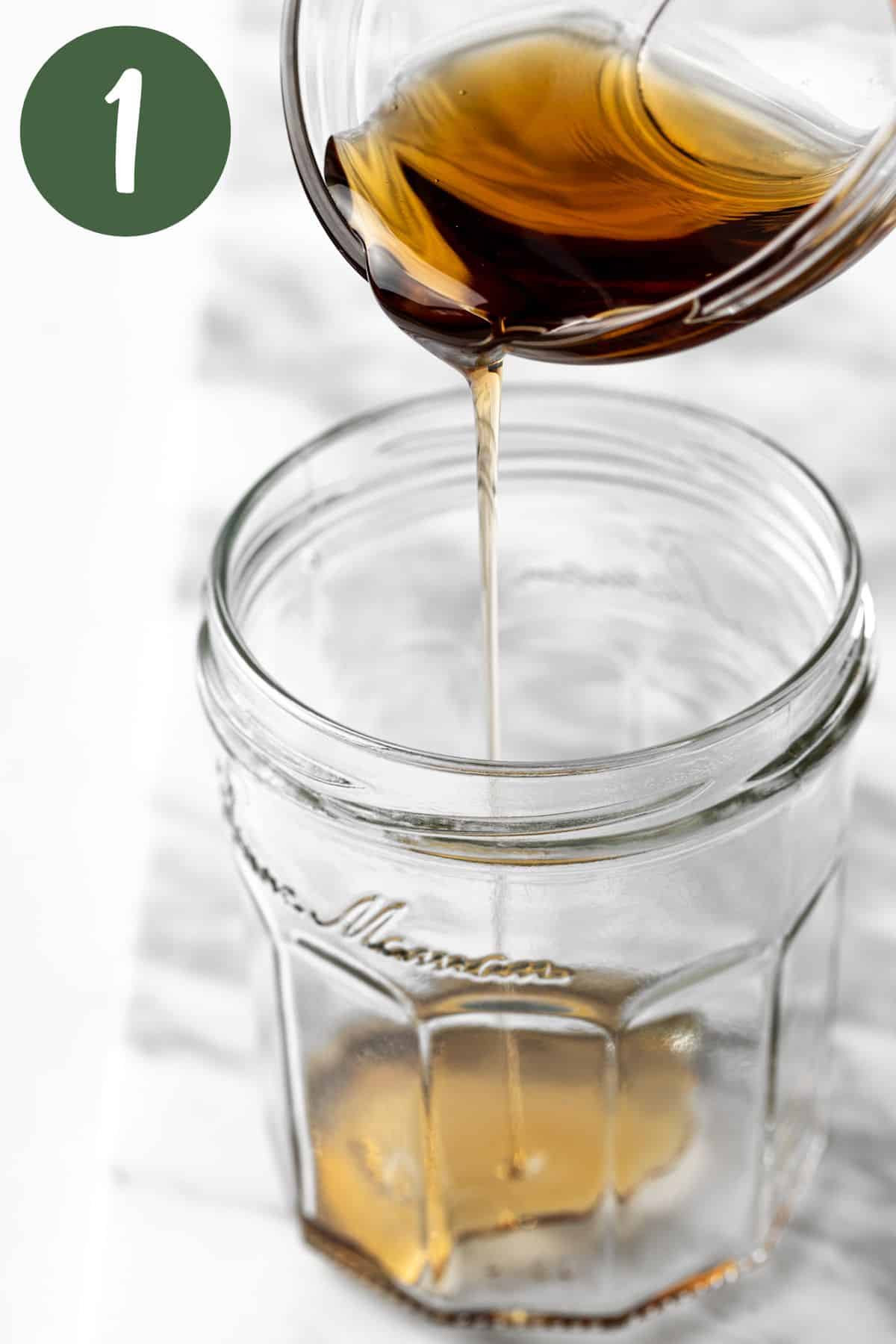 Pouring the maple syrup into a mason jar.