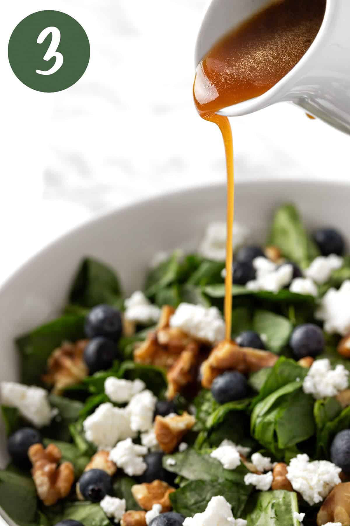 Pouring the maple vinaigrette dressing on the goat cheese blueberry salad.