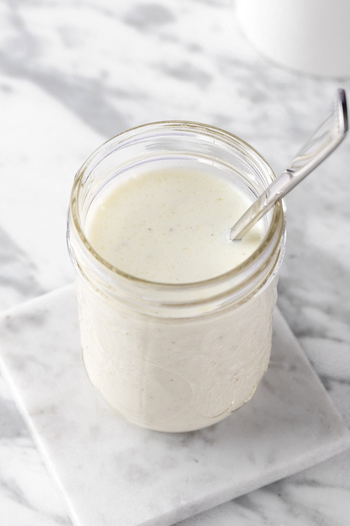 A mason jar or white creamy tzatziki salad dressing.