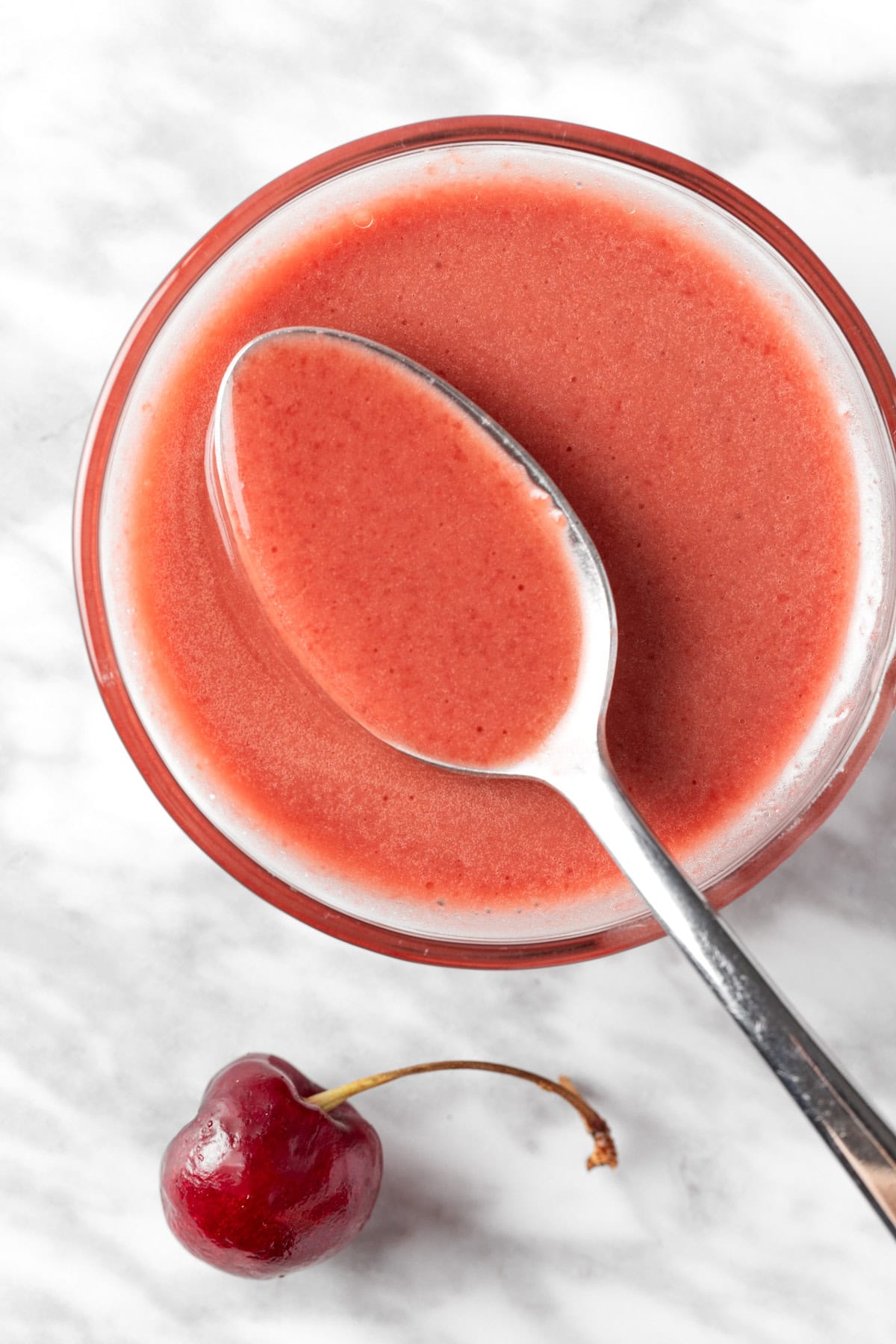 Overhead view of a spoonful of cherry balsamic vinaigrette.