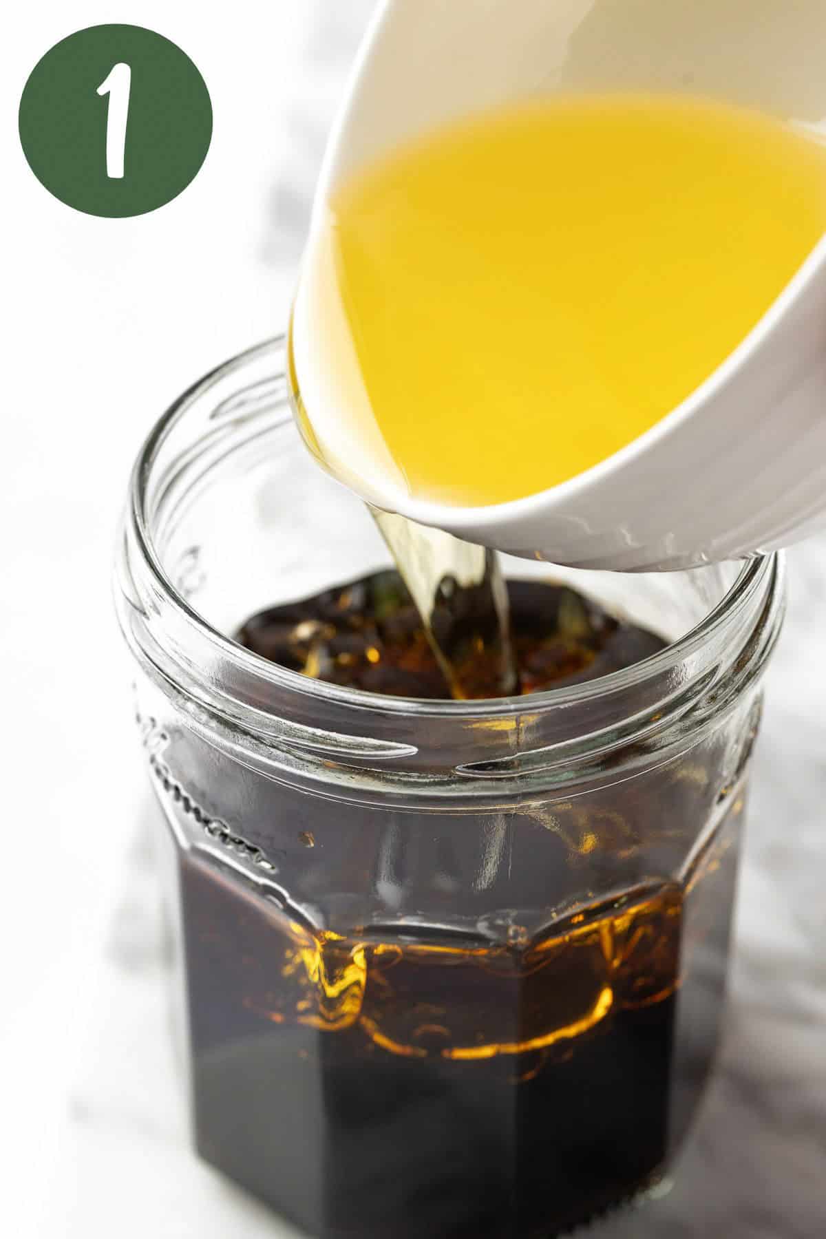 Pouring the sunflower oil into a mason jar with the other balsamic vinaigrette dressing ingredients.