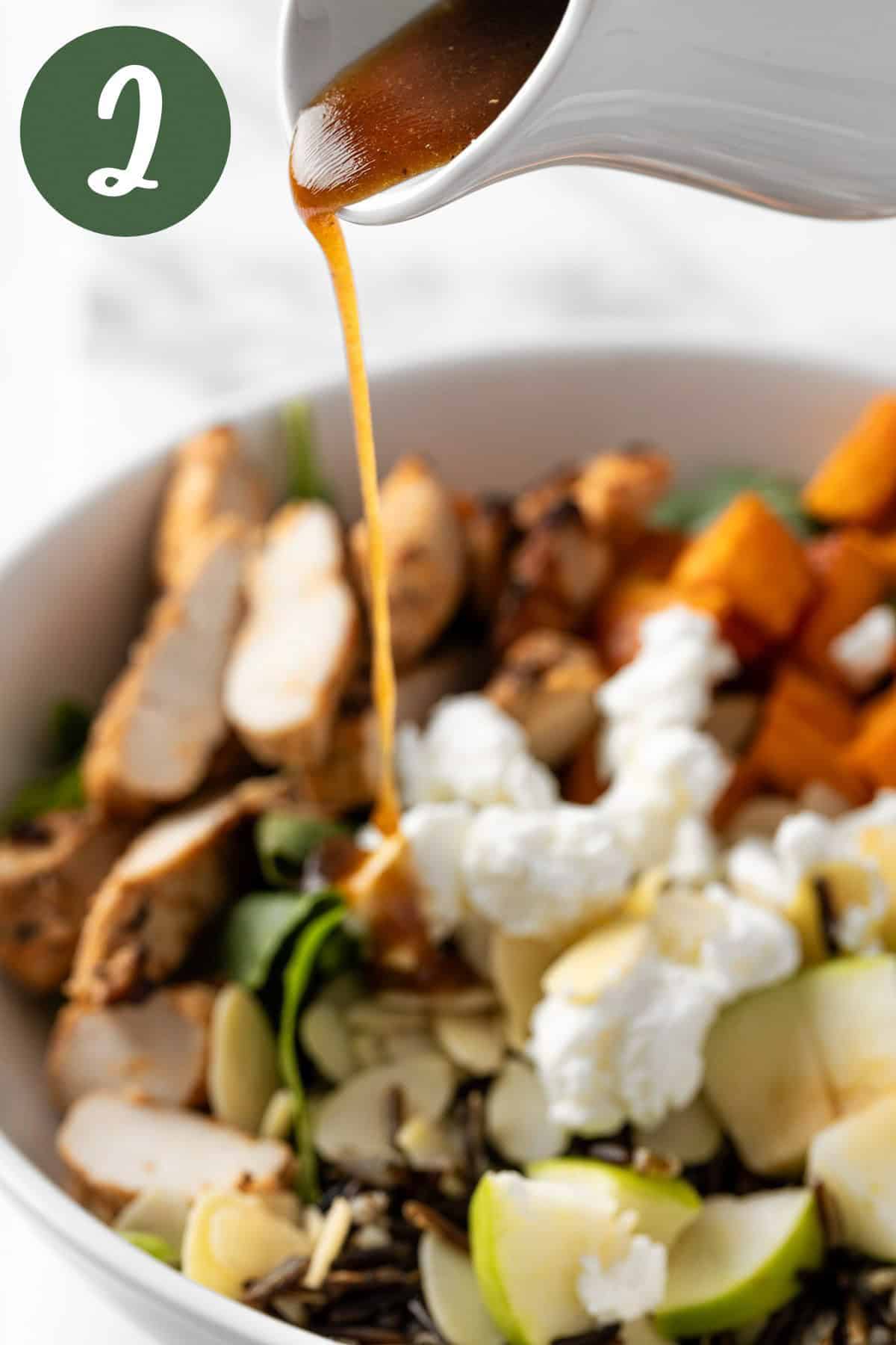 Pouring the balsamic vinaigrette dressing over the Harvest Bowl salad.