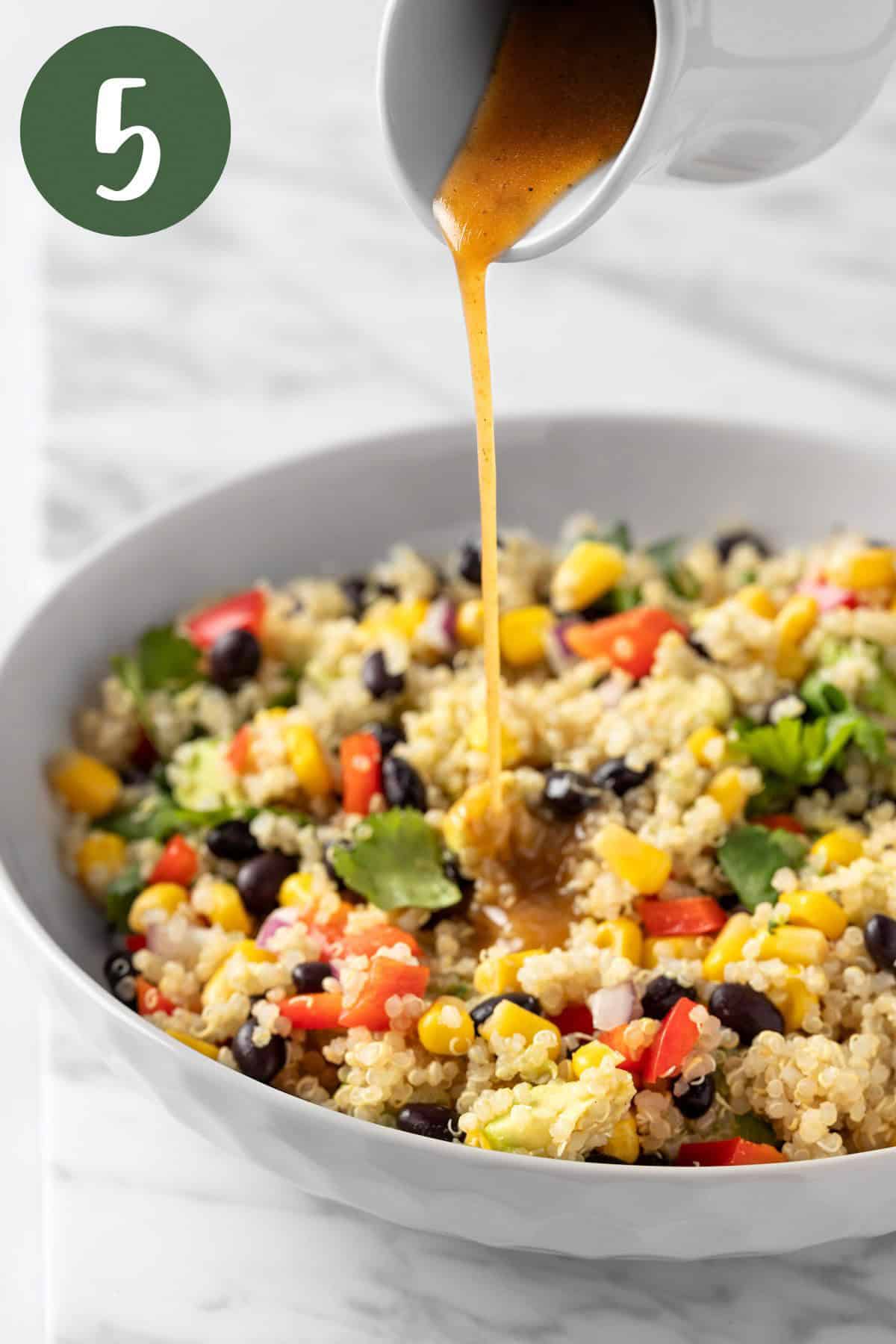 Pouring the chili lime vinaigrette over the Southwest Quinoa Salad.