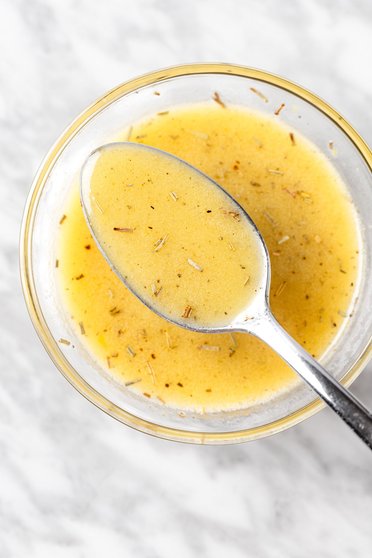 Overhead view of a spoon of lemon dijon dressing.