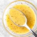Overhead view of a spoon of lemon dijon dressing.