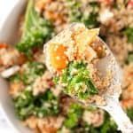 An up-close spoonful of sweet potato quinoa salad with kale and feta, topped with a balsamic date vinaigrette.