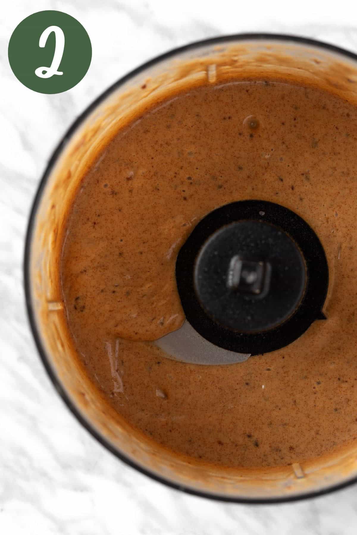 A process photo of the dressing ingredients blended together in a food processer.
