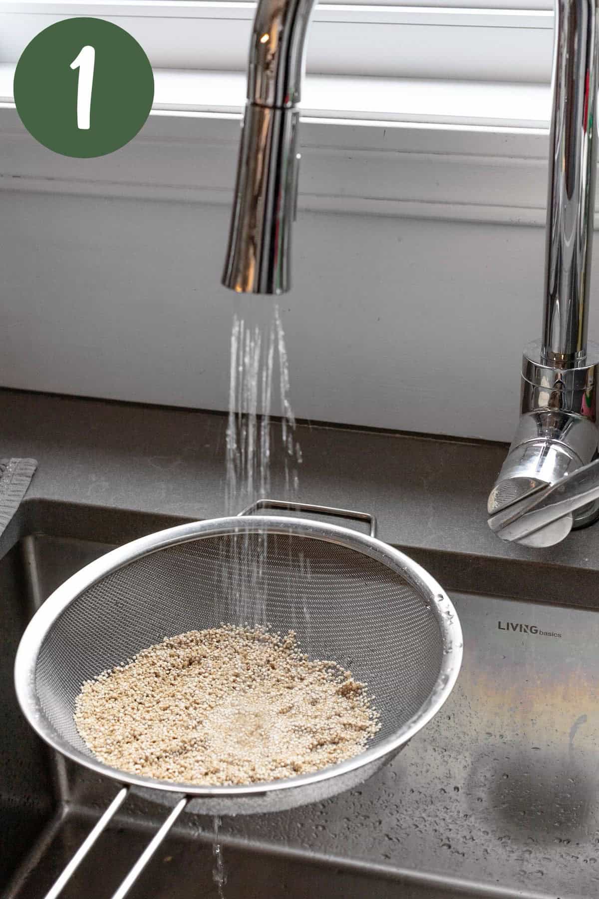 Rinsing the quinoa under cold water in a sieve.