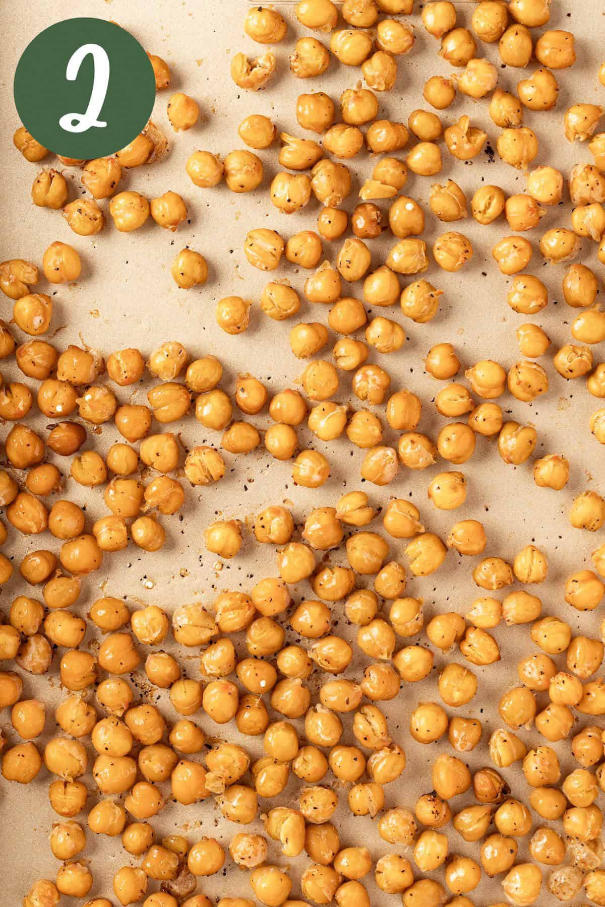 Roasted chickpeas seasoned with olive oil, salt and pepper on a baking sheet.