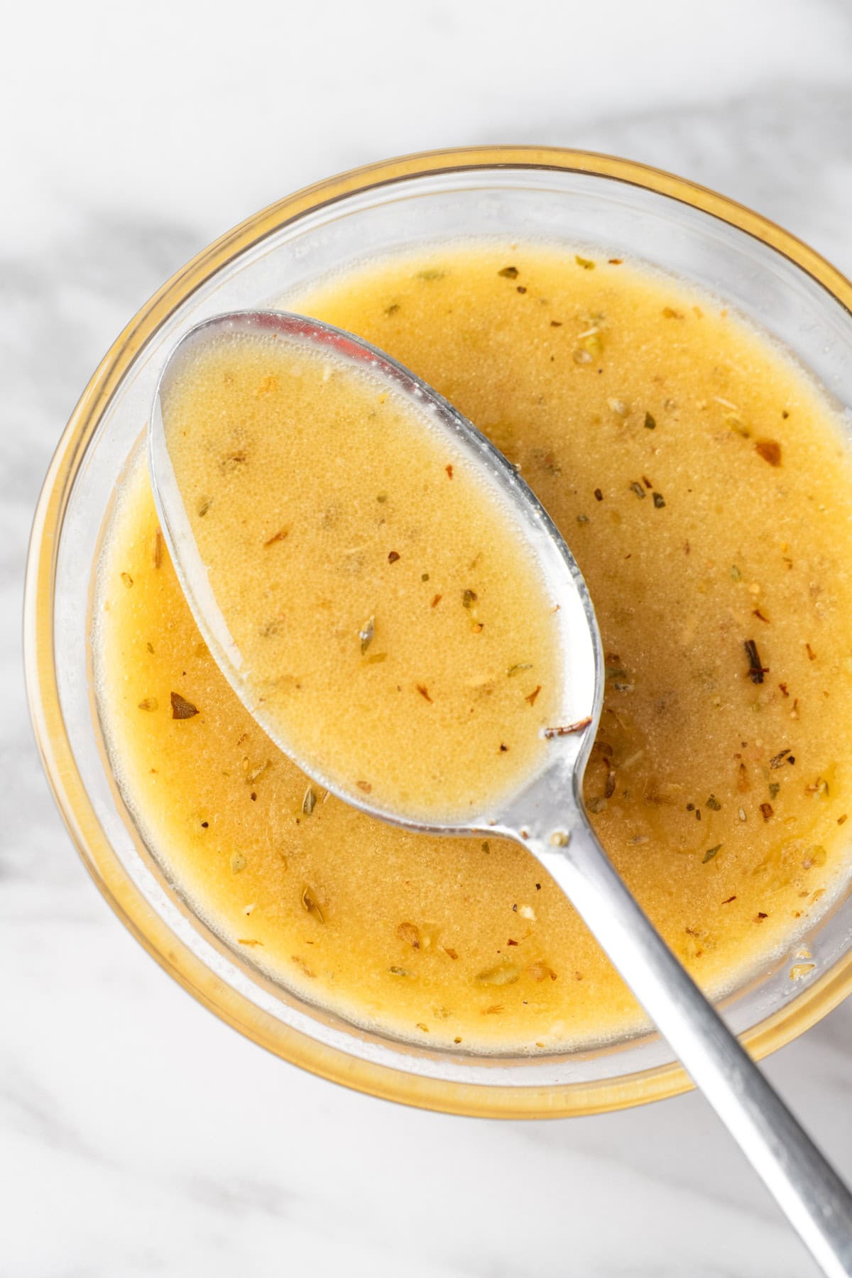 Overhead view of a spoonful of red wine vinaigrette dressing.