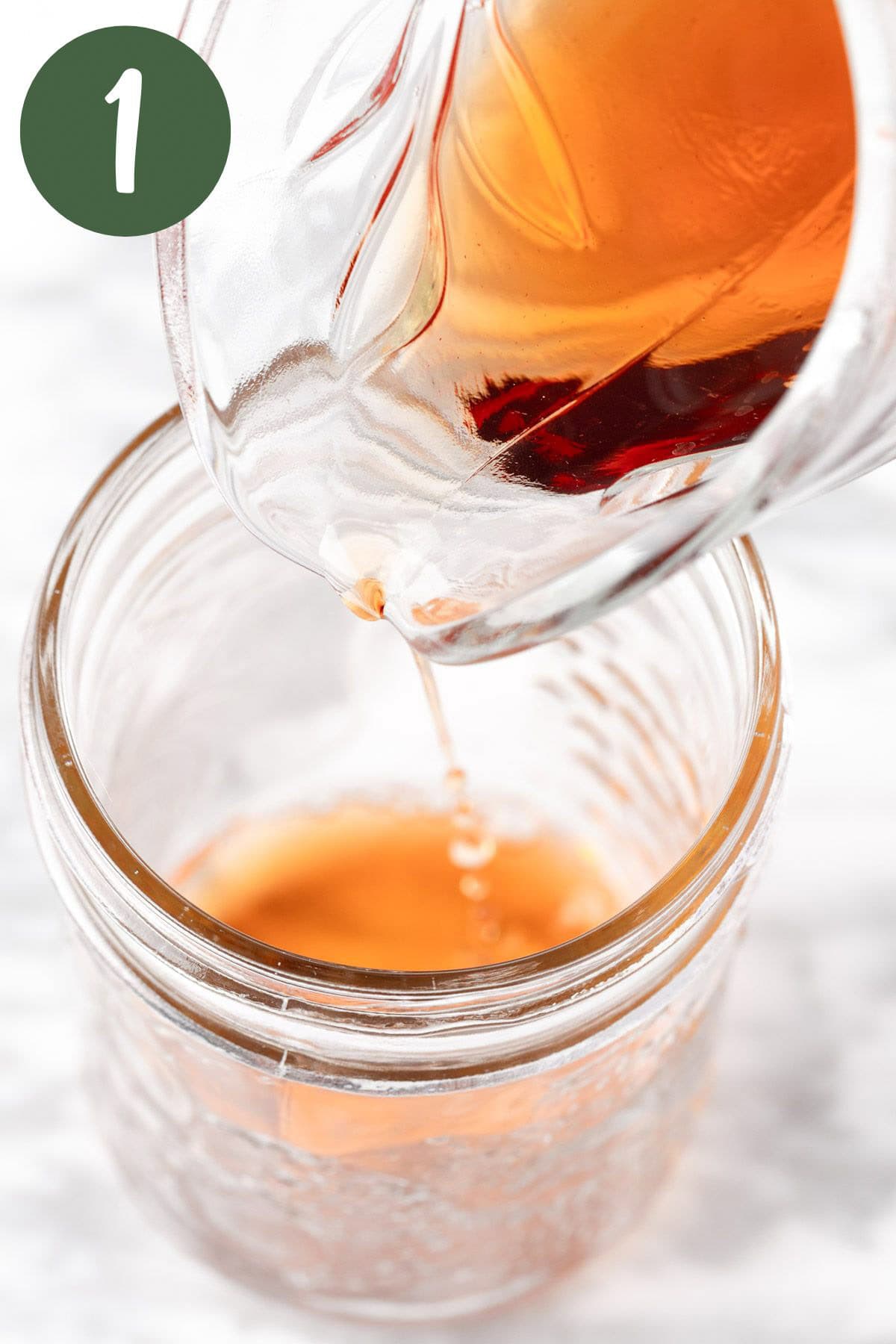 Pouring the red wine vinaigrette into a mason jar.