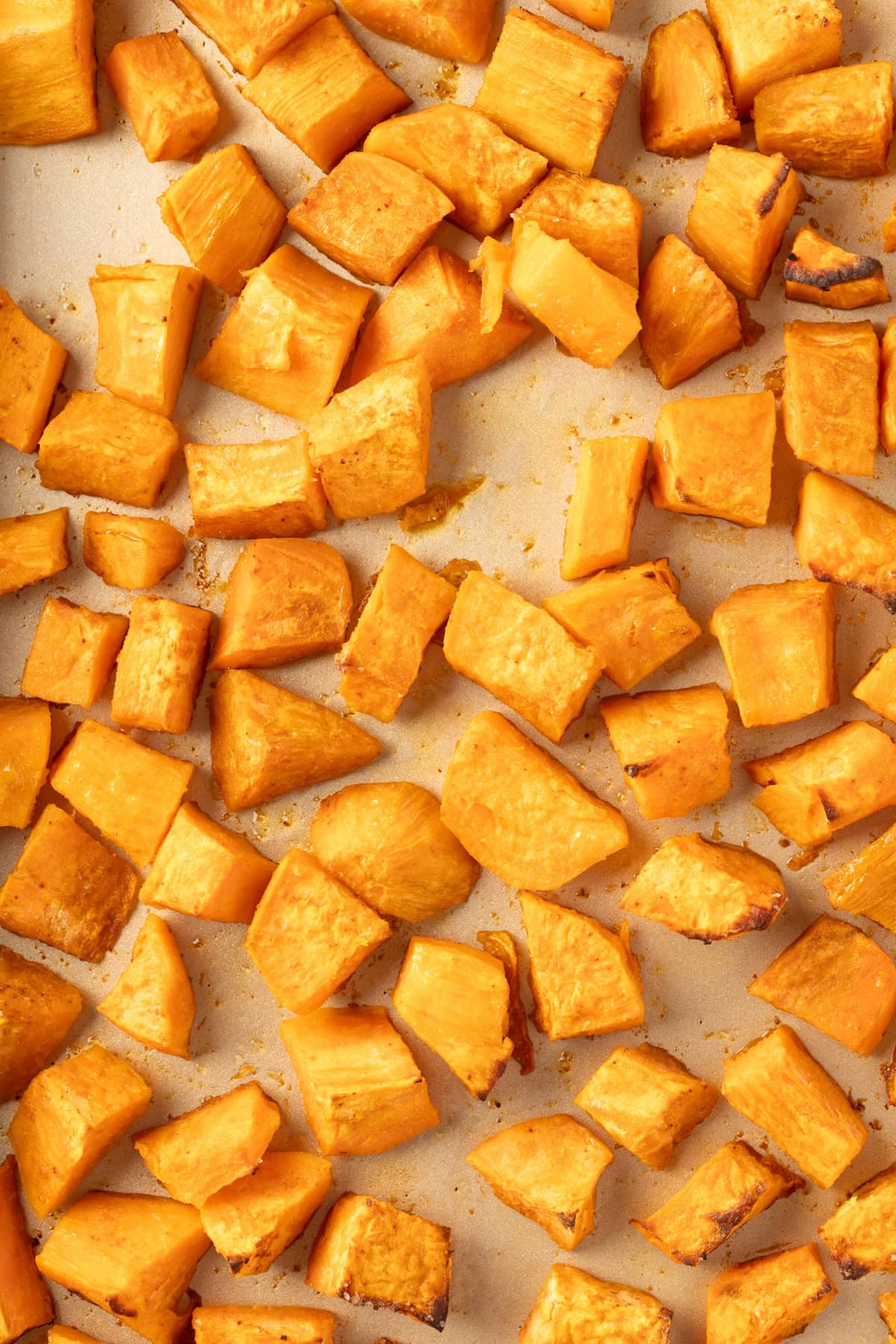 A baking sheet of roasted sweet potatoes fresh out of the oven.