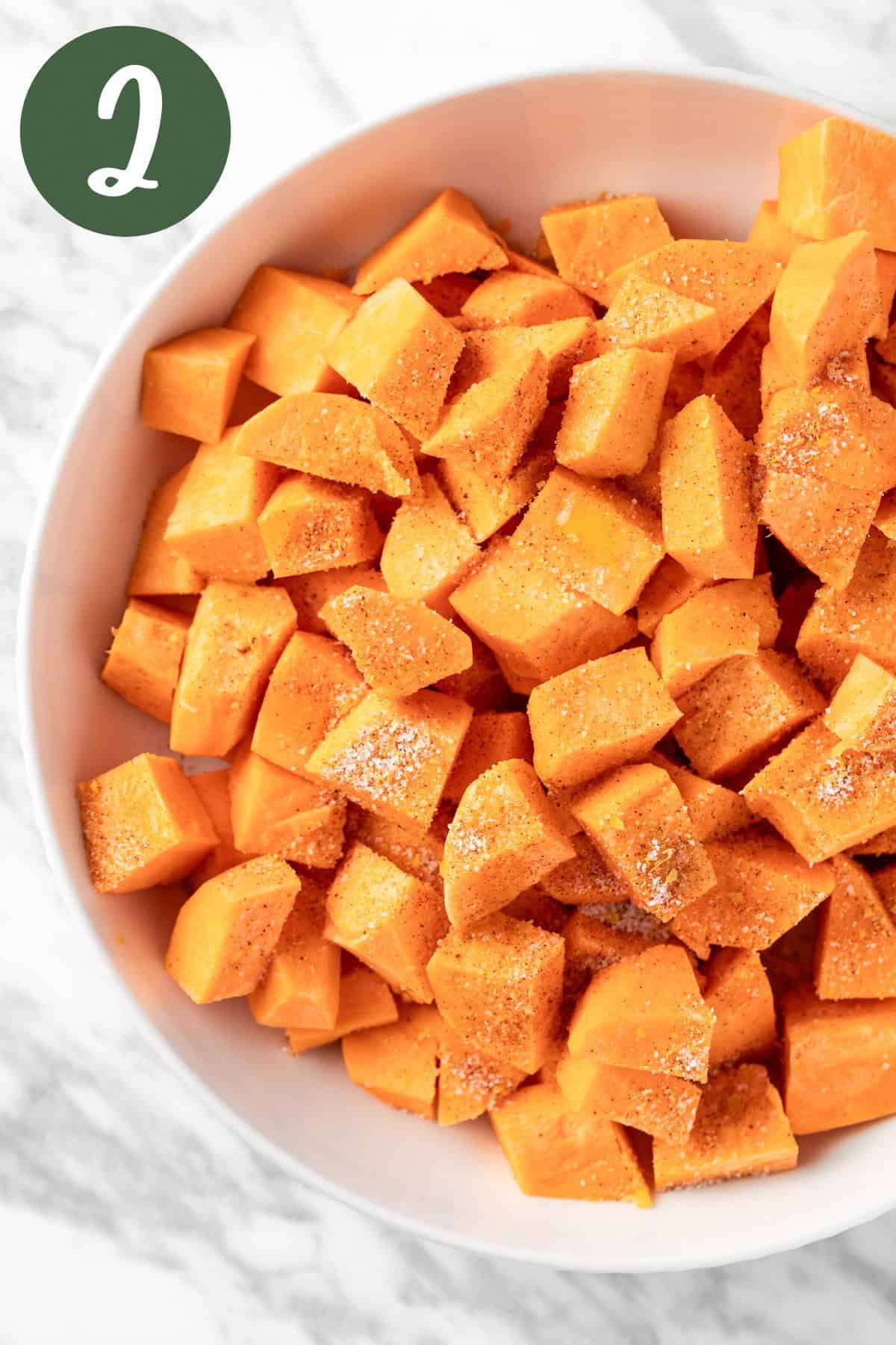 A white bowl of sweet potatoes covered with Sweetgreen umami seasoning.