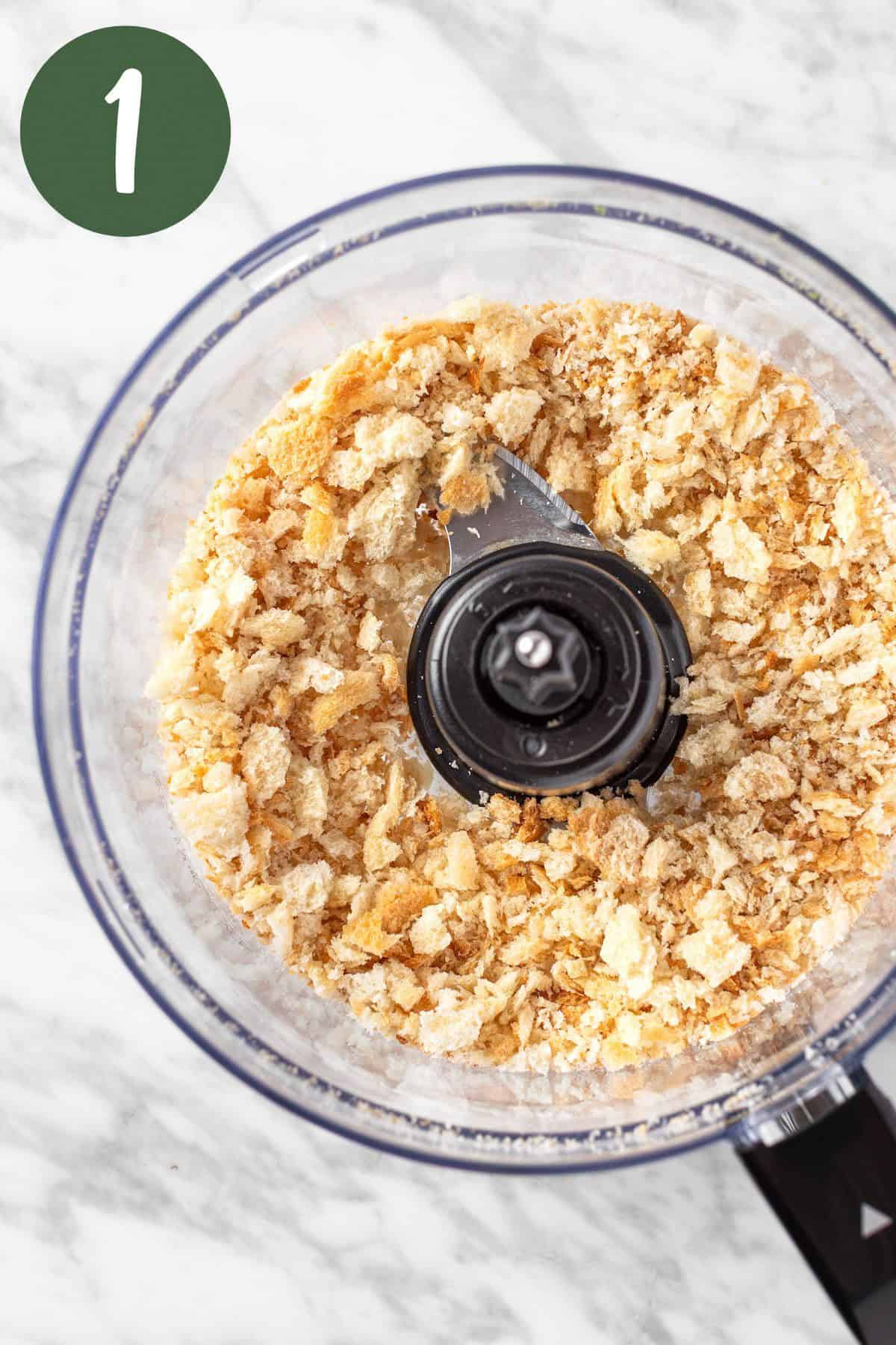 A process photo of the breadcrumbs being blended in a food processor.