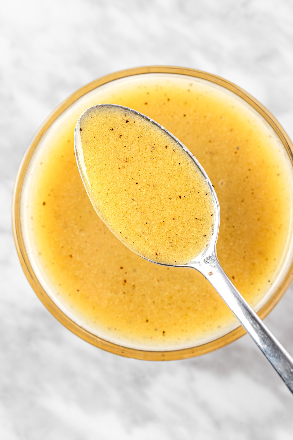 An up close spoonful of apple cider and dijon mustard vinaigrette.