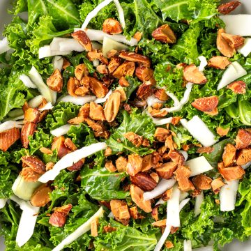 Overhead view of a bowl of Chick-Fil-A Kale Crunch salad made withe kale, roasted almonds, green cabbage and topped with an apple cider dijon vinaigrette.