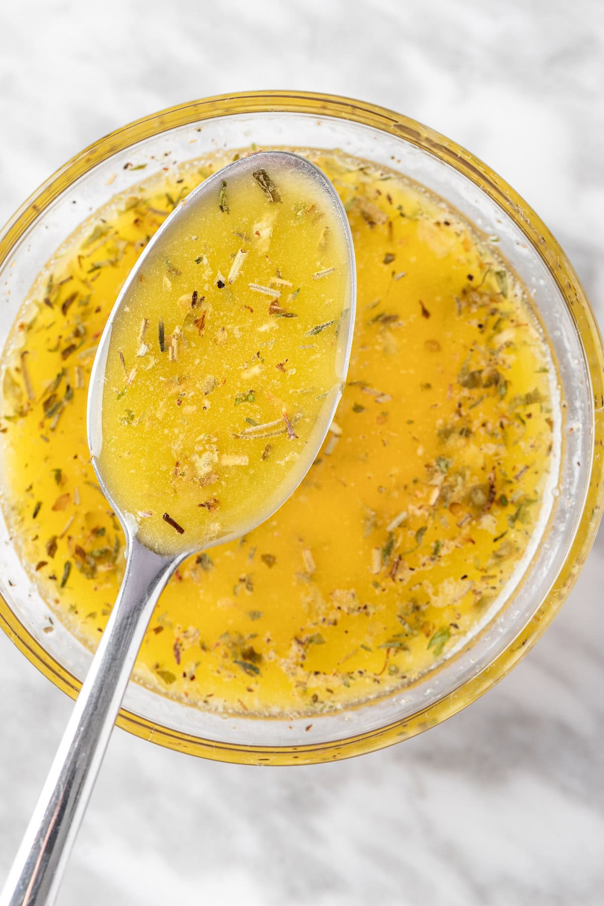 An overhead view of a spoonful of Panera Greek Salad Dressing.