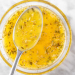 An overhead view of a spoonful of Panera Greek Salad Dressing.