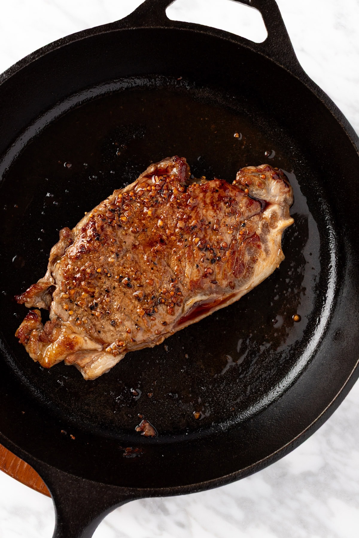 Cooked steak in a cast iron skillet.